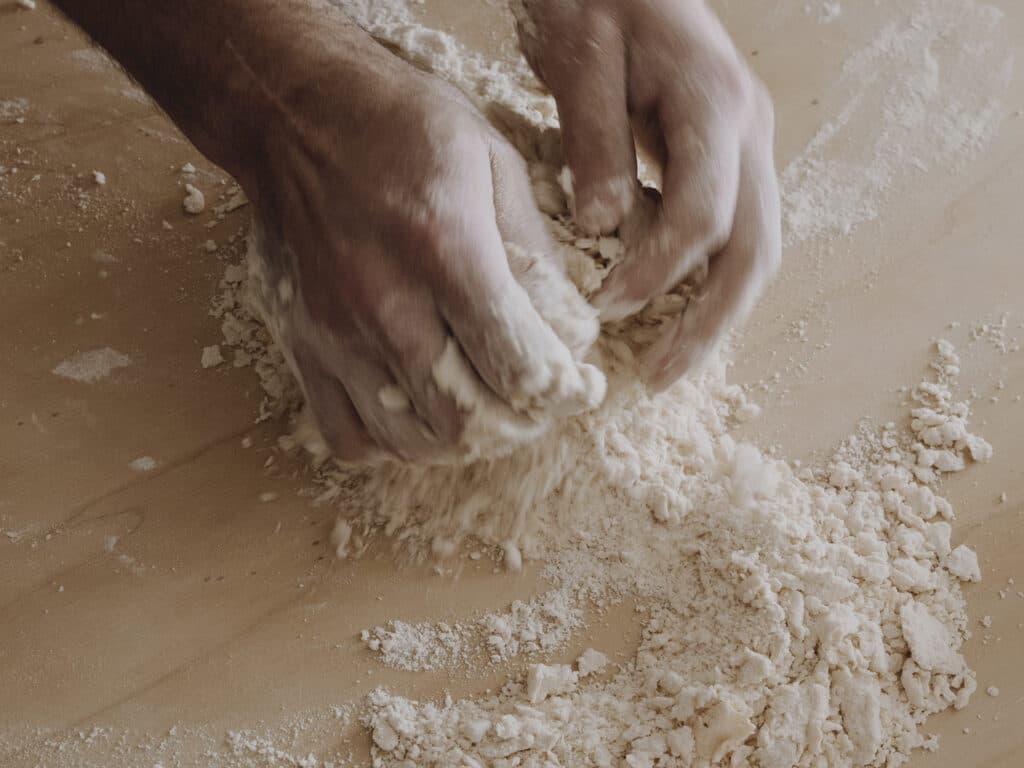 Bild på händer som knådar en deg