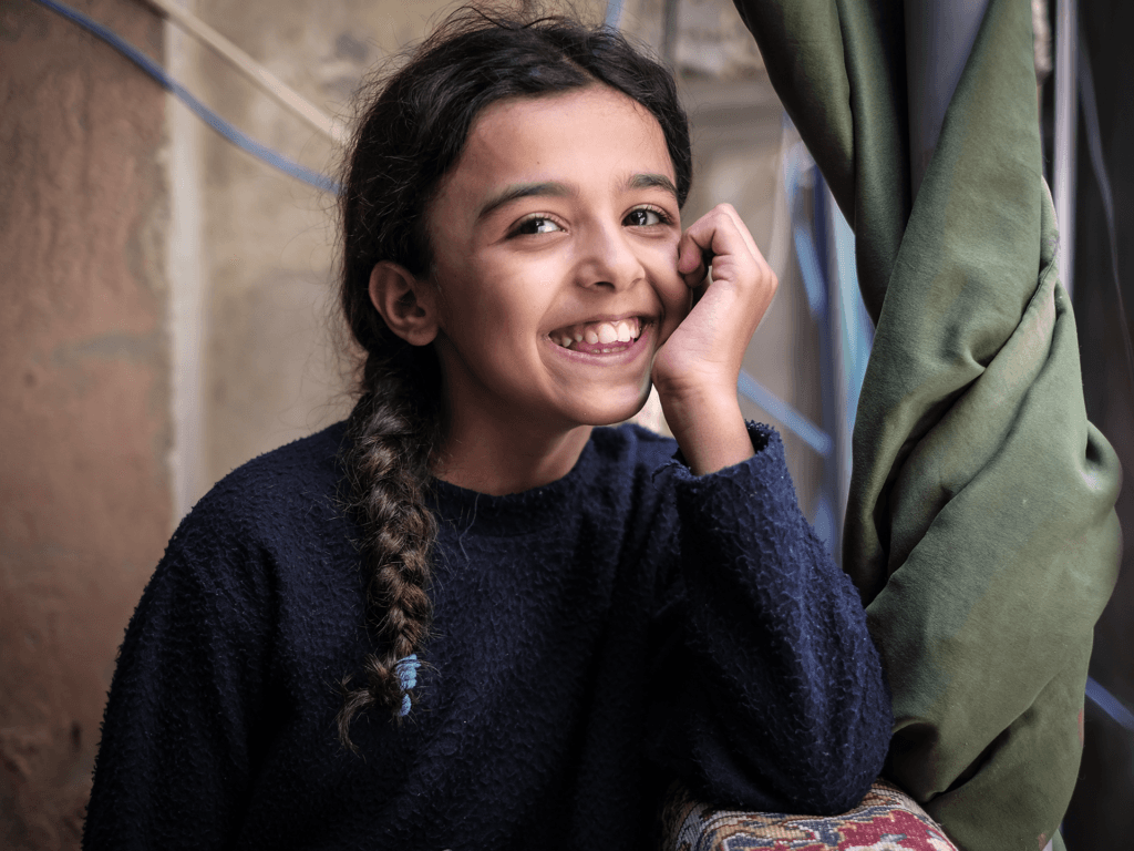Foto på leende flicka i ett av Libanons flyktingläger