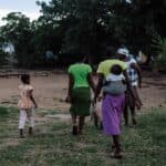 Grupp med kvinnor och barn går på gräsplan