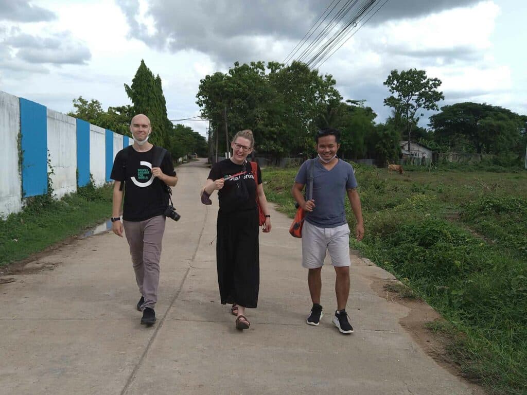 Två män och en kvinna går på en väg