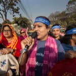 En grupp kvinnor varav en talar i mikrofon.