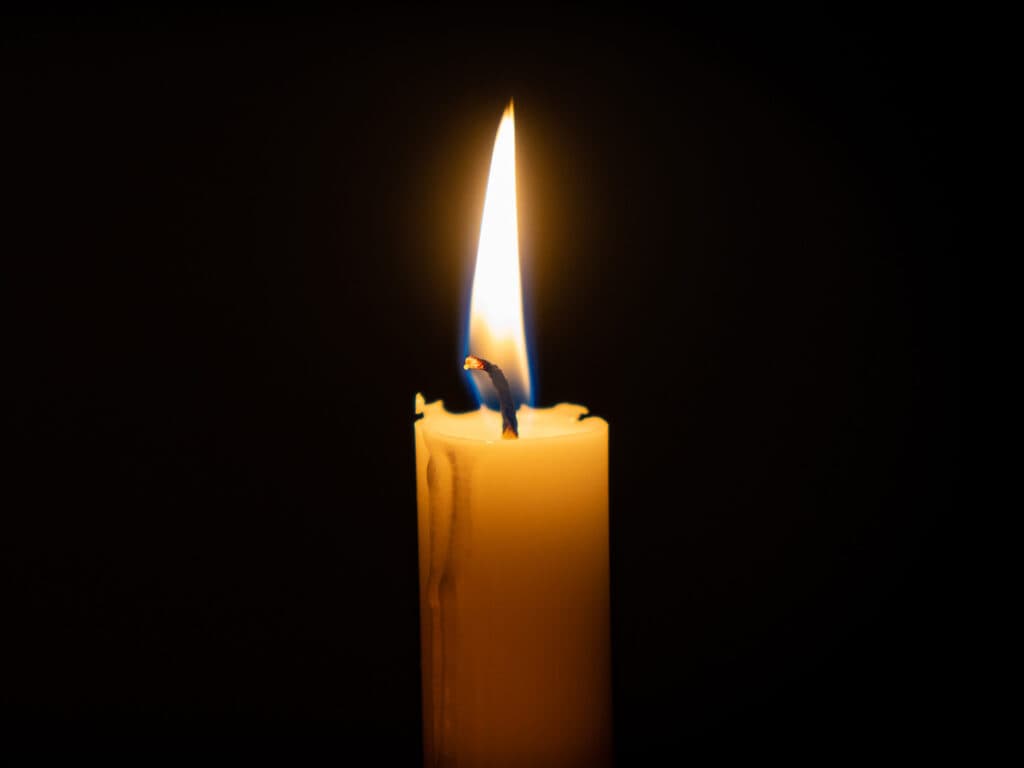 Närbild av ett tänt stearinljus