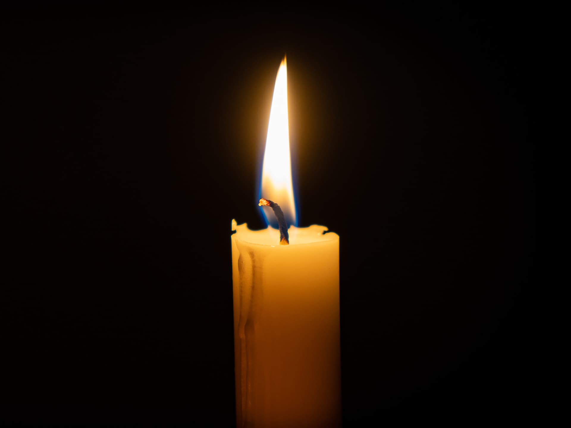 Närbild av ett tänt stearinljus