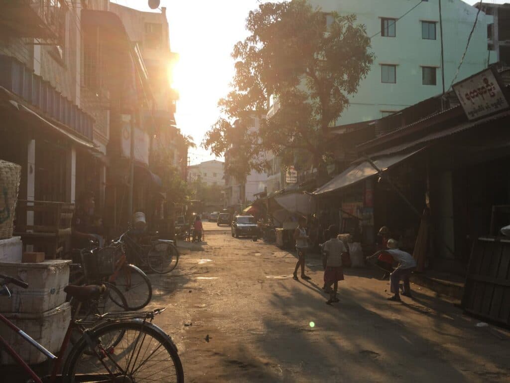 A street scene with houses and children playing in the street.
