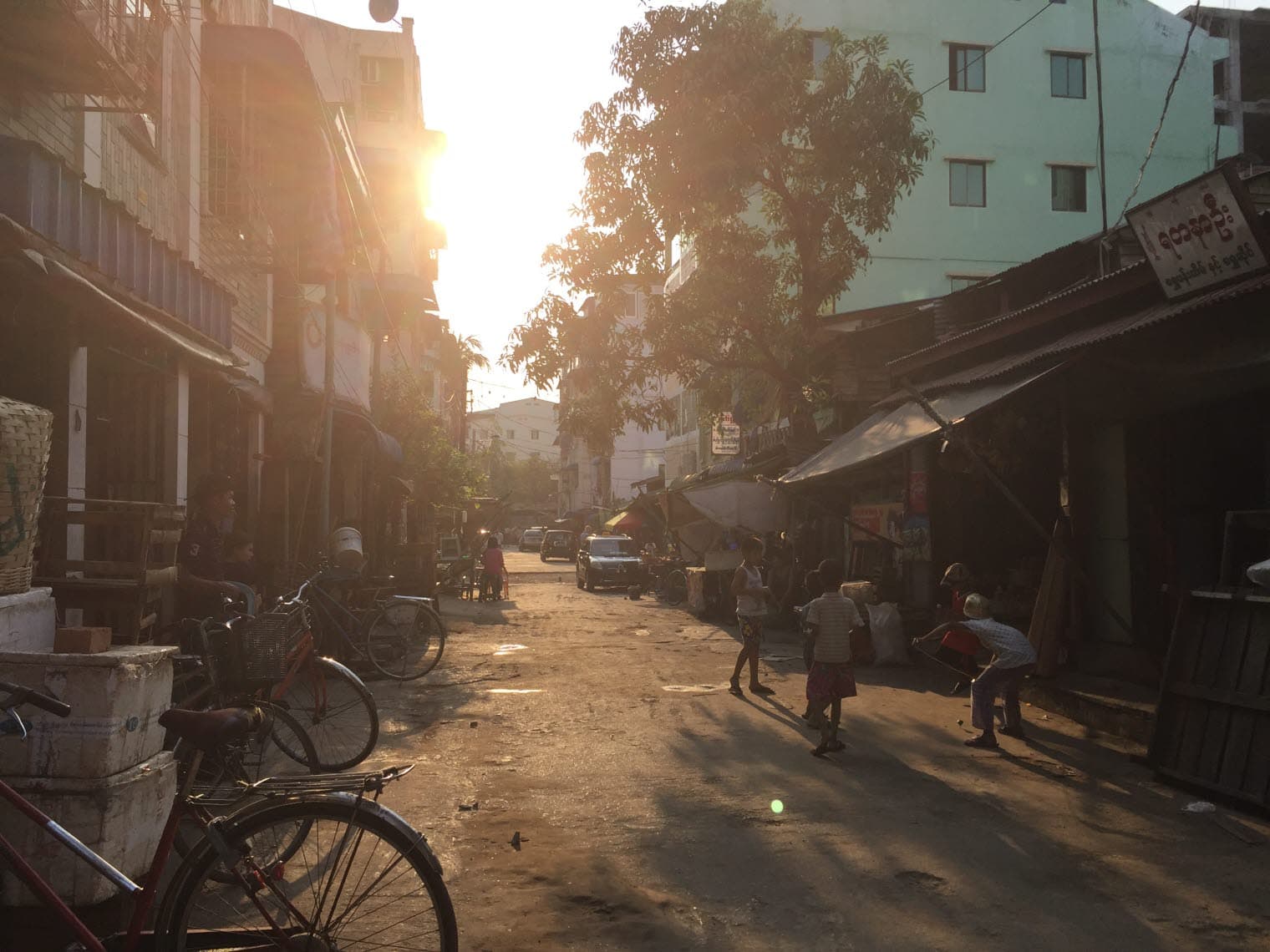 A street scene with houses and children playing in the street.