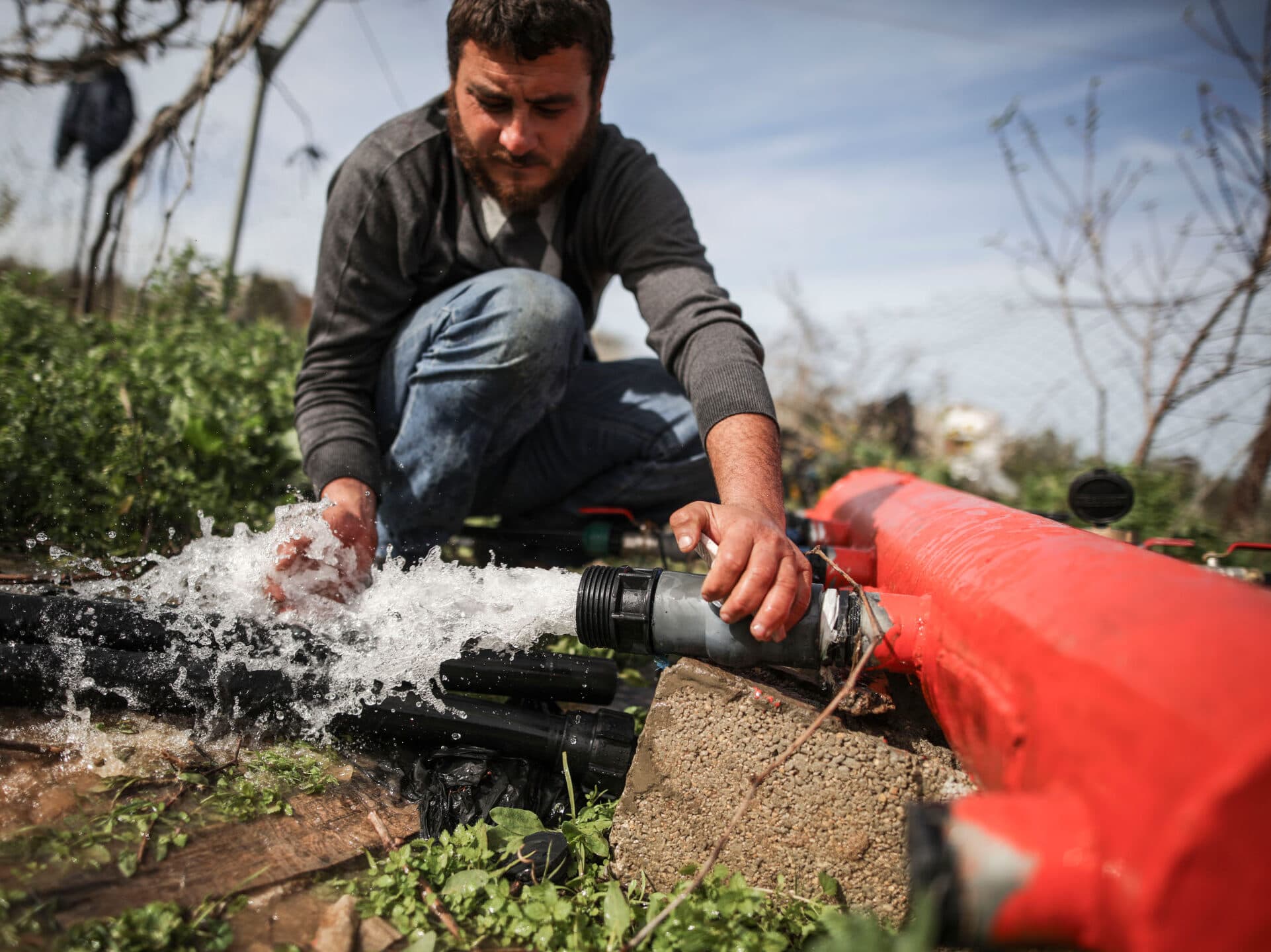A man installs a water pipeline on a field.