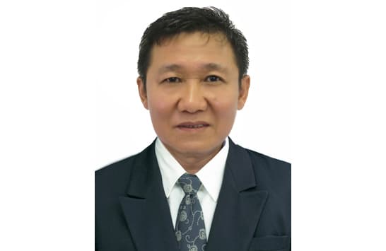 A portrait of a man in a suit and tie, white background.