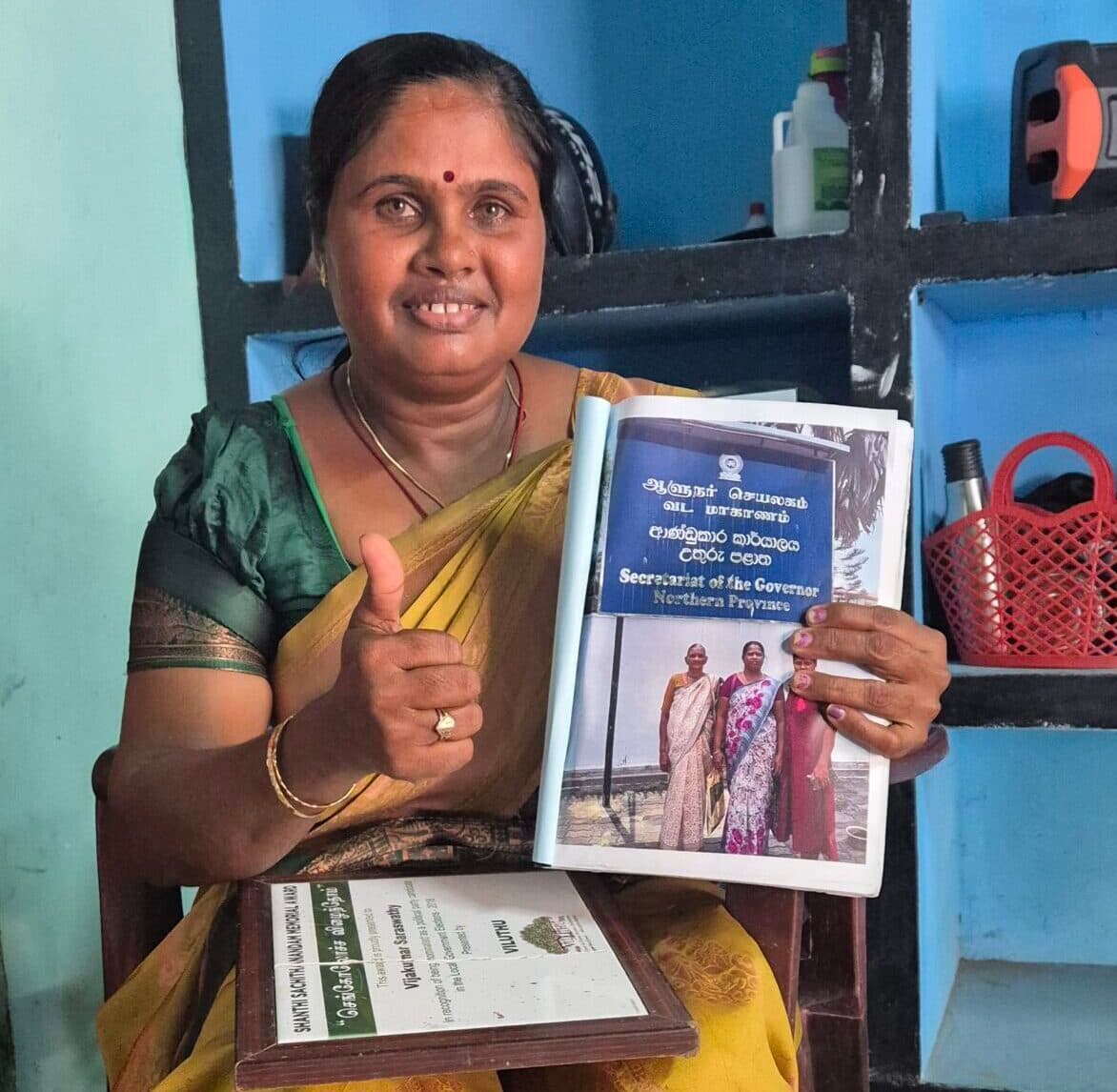 A portrait of South Asian woman sitting and holding a book