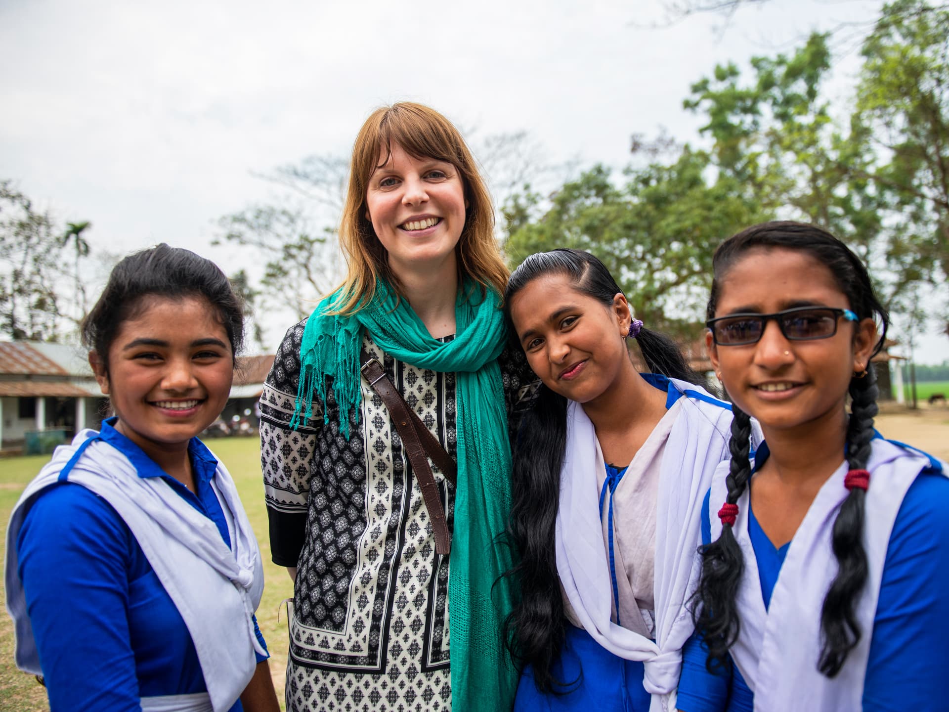 Foto: Gustav Hugosson Ida från Diakonia tillsammans med tre flickor i skoluniform