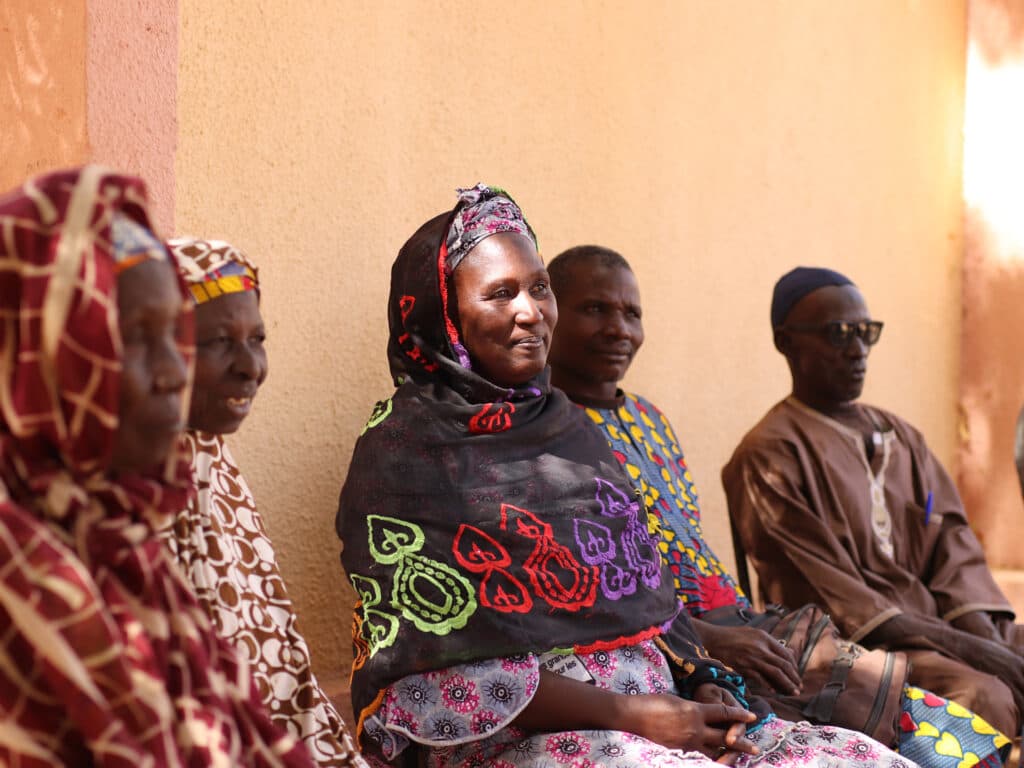 Foto: Diakonia Män och kvinnor sitter tillsammans vid en väg
