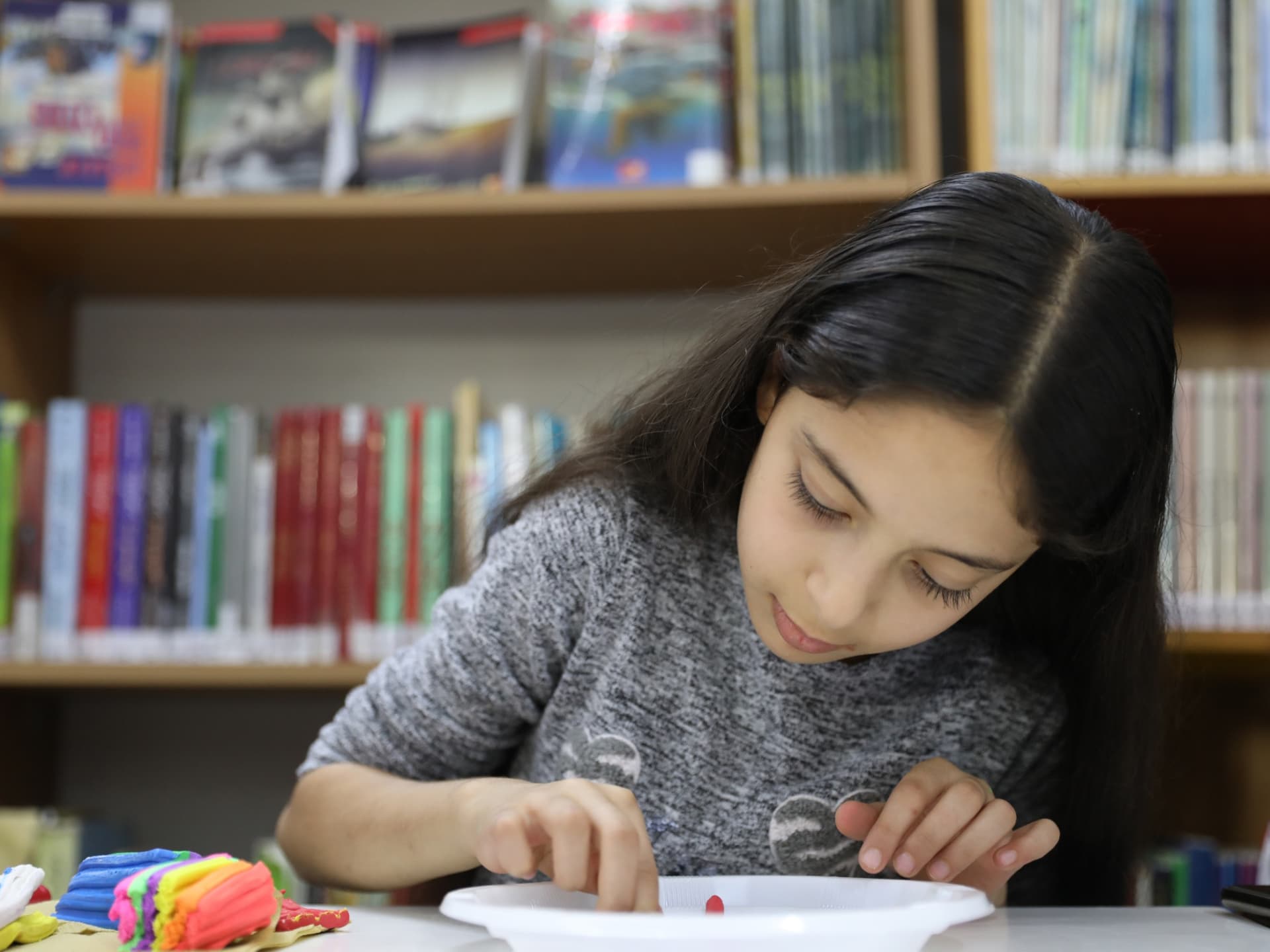 Foto: Abu Rahmah En flicka arbetar med lera