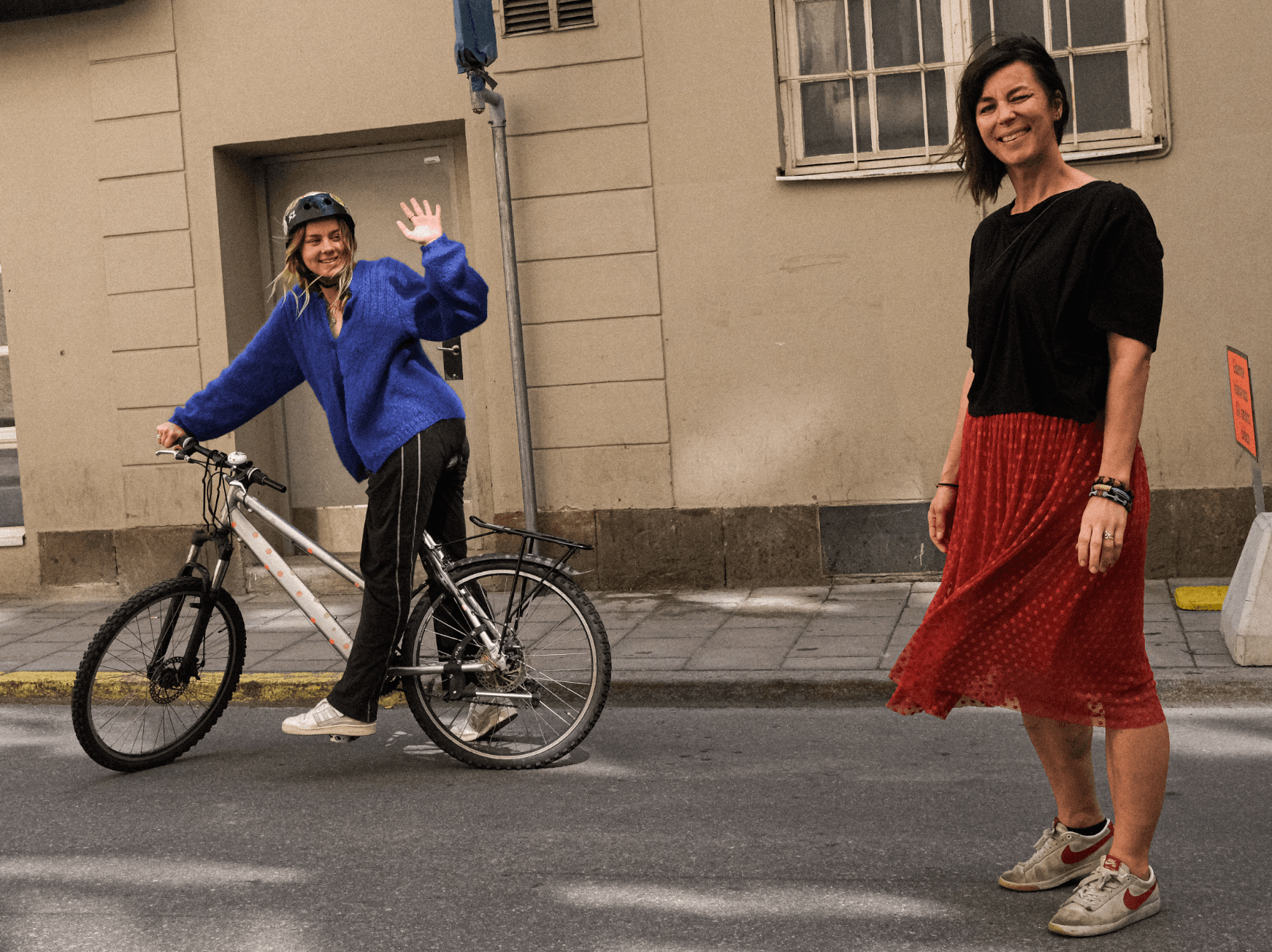 Foto: Isabelle McAllister En ung tjej på cykel vinkar till en kvinna