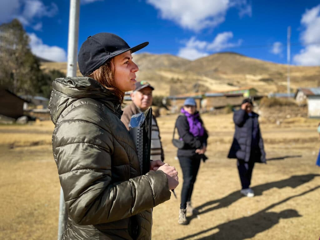 Foto: Siara Horna En kvinna med keps i framgrunden, en grupp människor längre bak.