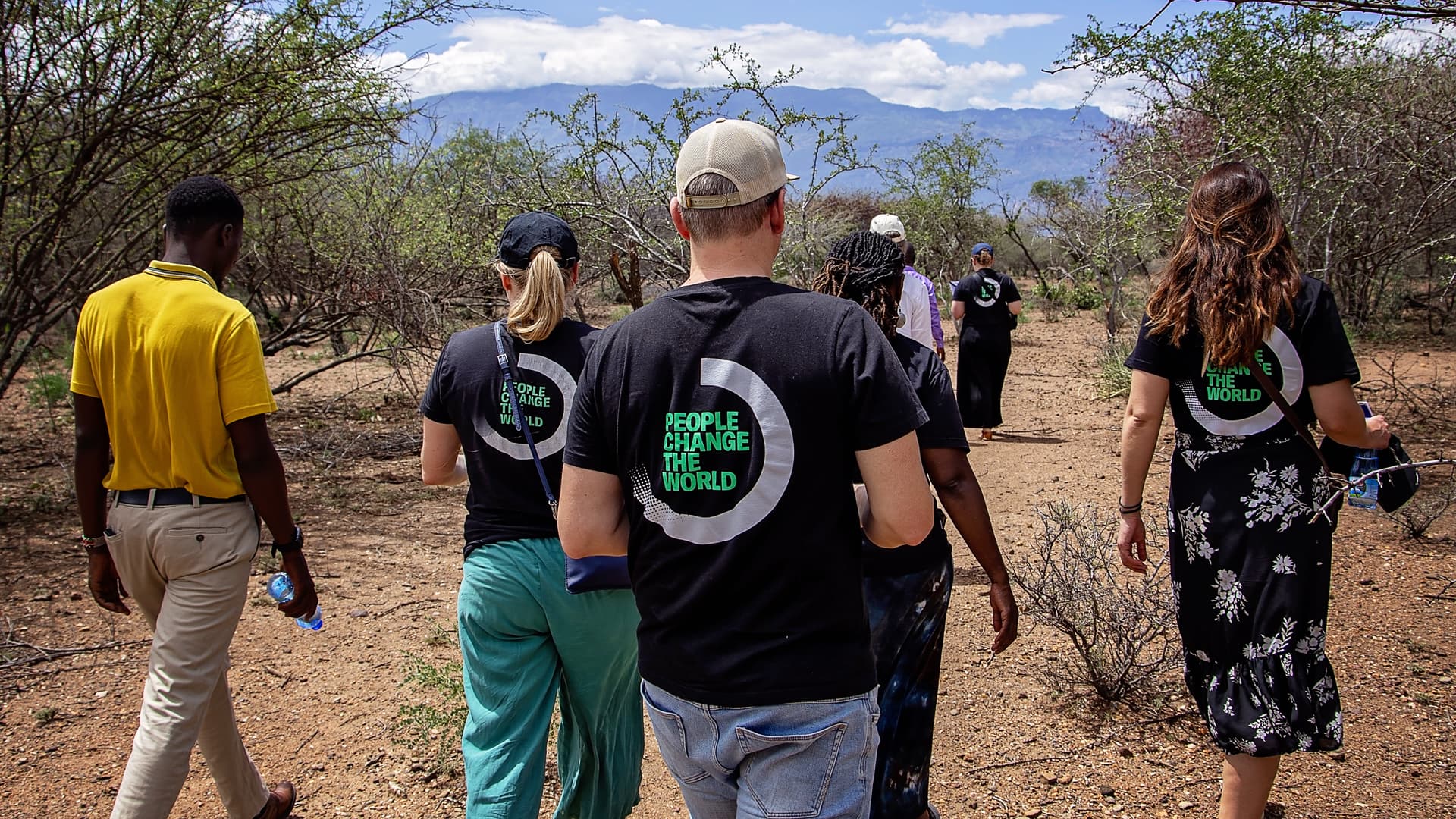 Foto: Diakonia En grupp människor med likadana tröjor med texten "People change the world" har ryggarna mot kameran.