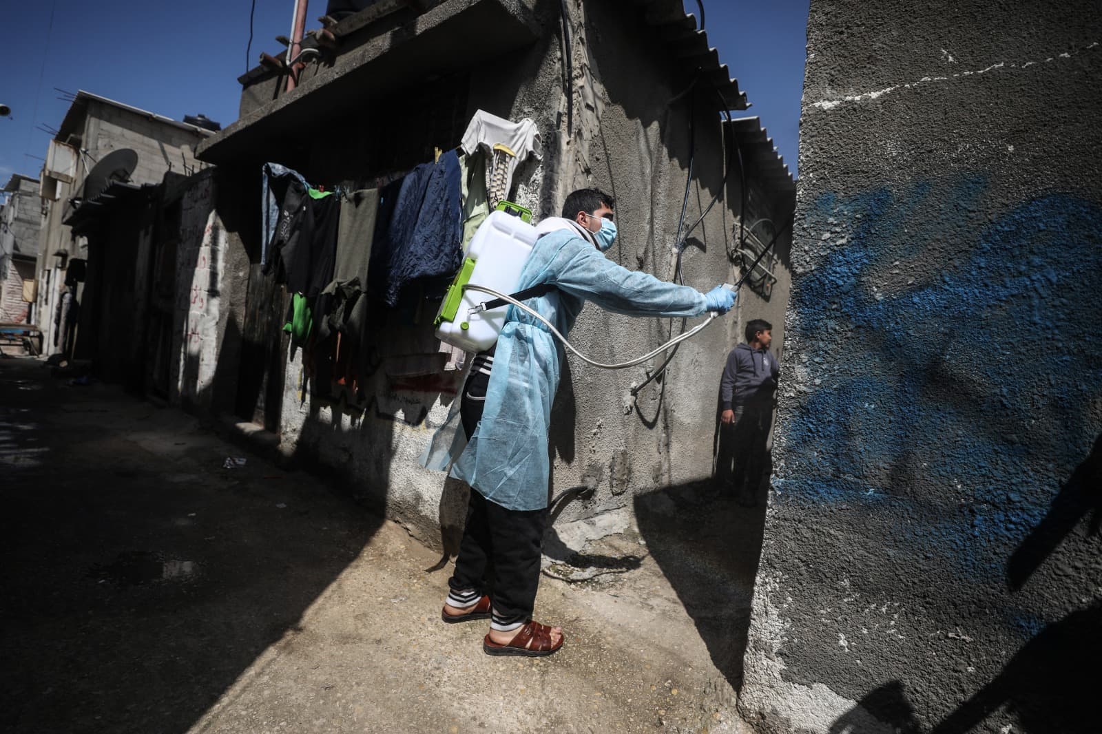A health worker sanitising houses in a poor neighborhood in the Gaza Strip. A health worker sanitising houses in a poor neighborhood in the Gaza Strip.