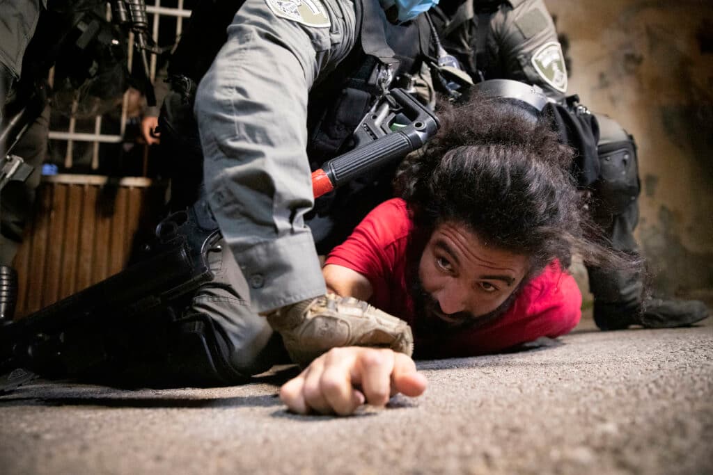 A person pressed down to the street by a security officer. A person pressed down to the street by a security officer.