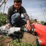 A man installs a water pipeline on a field.