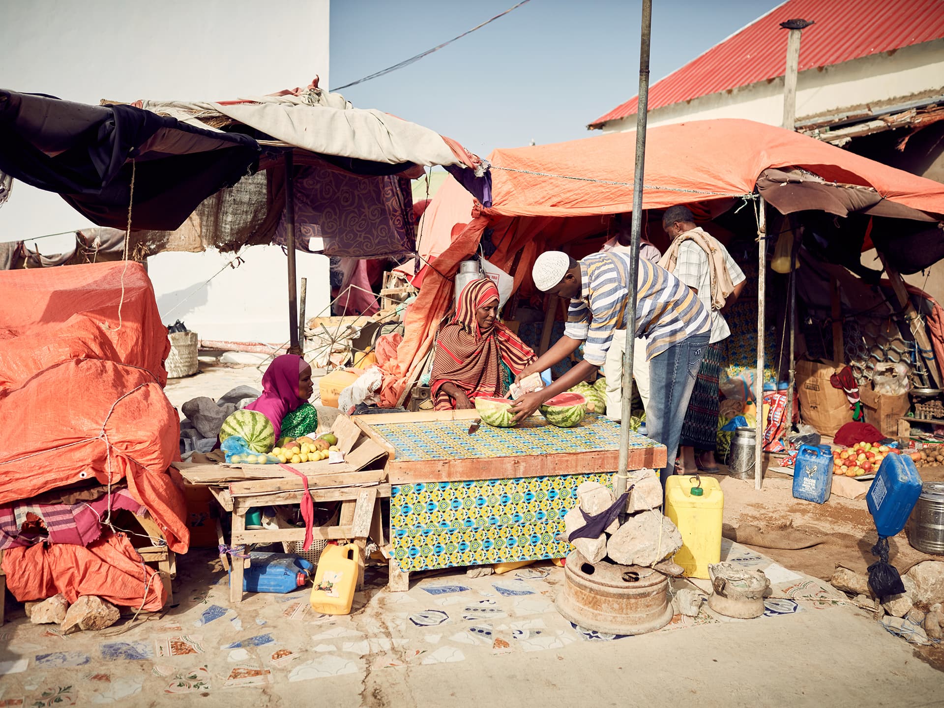 Photo: Juozas Cernius Tents in different colours and people sitting by it.
