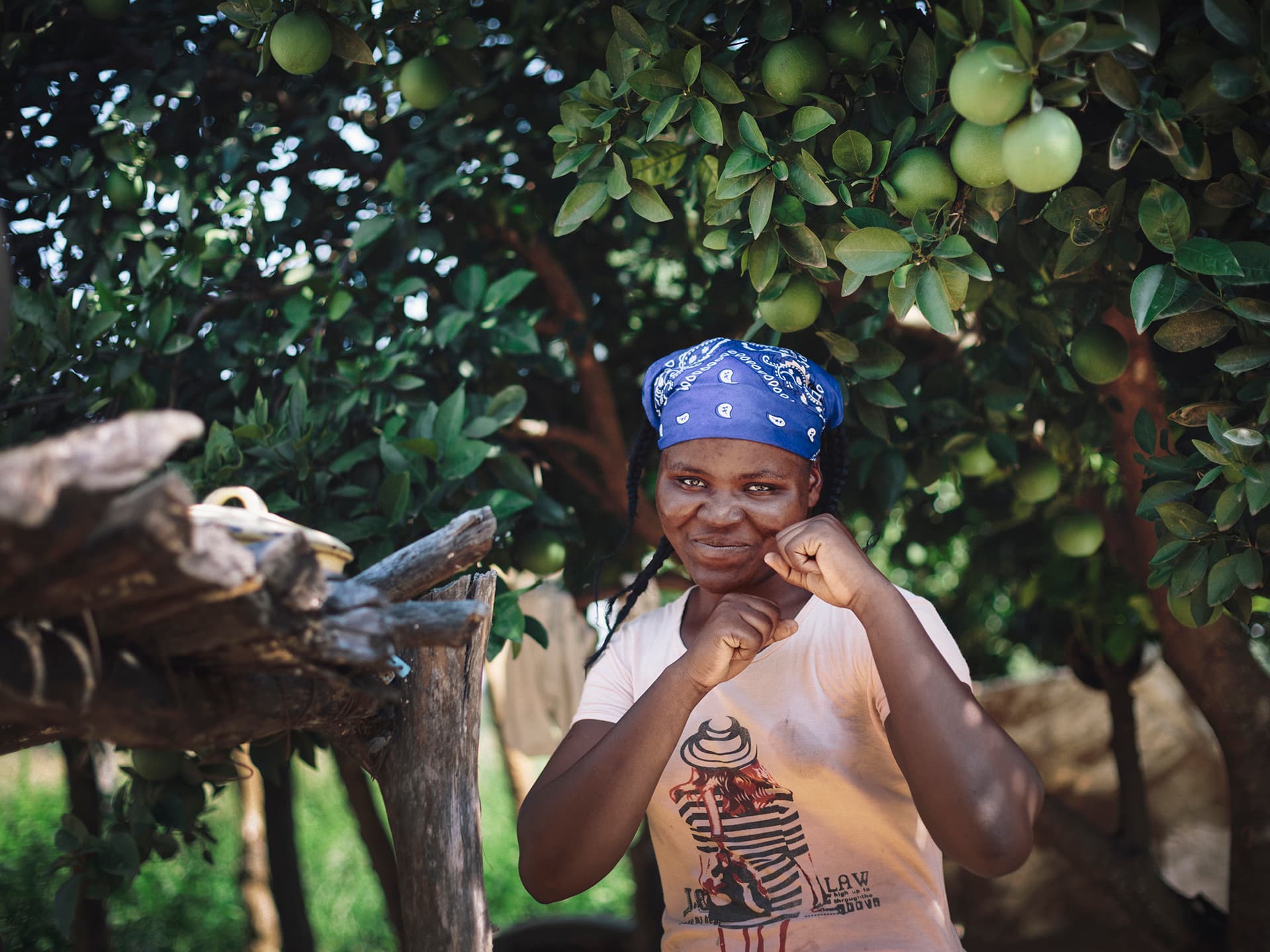 Photo: Diakonia A girl holding up her hands as boxing. In the background there's green.