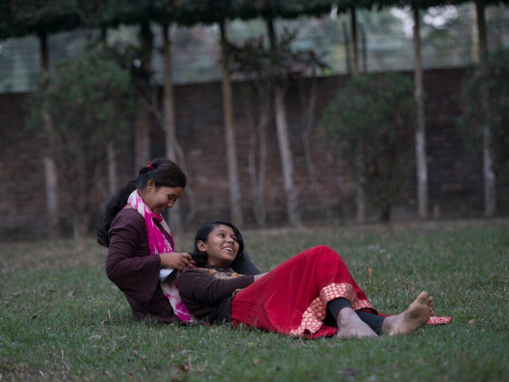 Systrarna Akhi och Sharifa på en gräsmatta