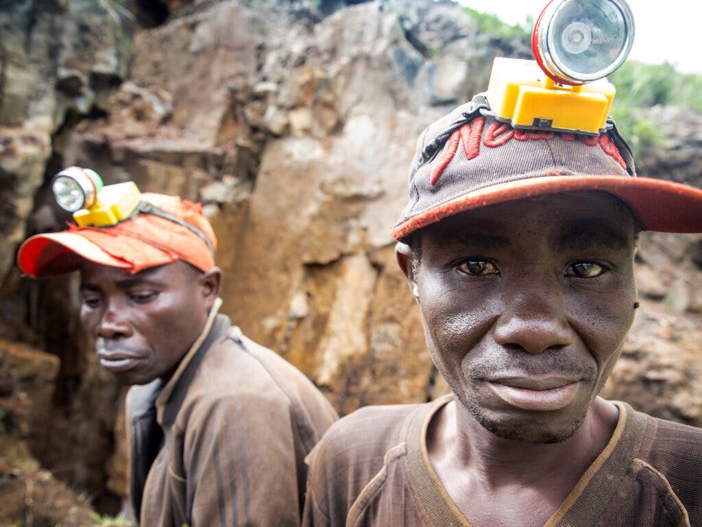 Två gruvarbetare i DRC utanför gruvöppningen.