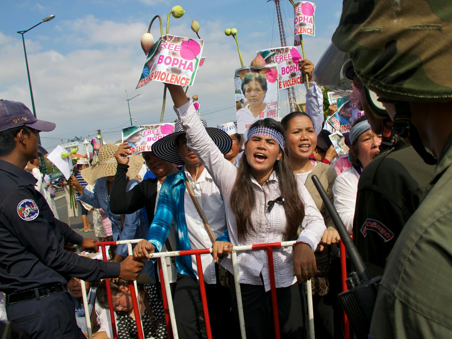 Aktivisten Tep Vammy vid ett stängsel med militärer framför