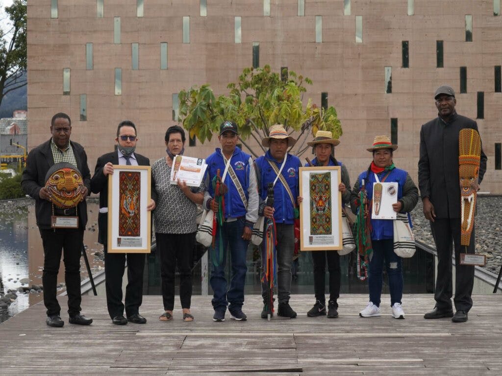 Colombianska människorättsförsvarare med priser i händerna framför byggnad i Bogota