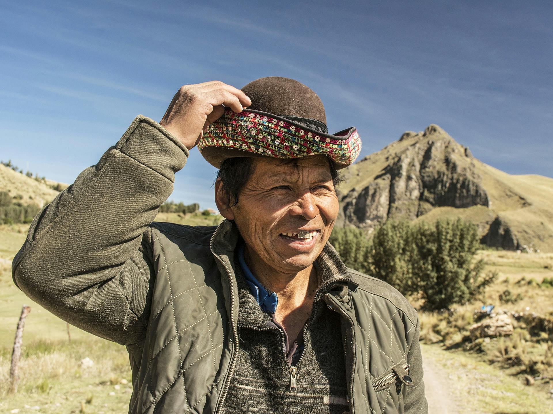 Porträtt av en äldre man med en hatt. I bakgrunden syns berg och slätter.