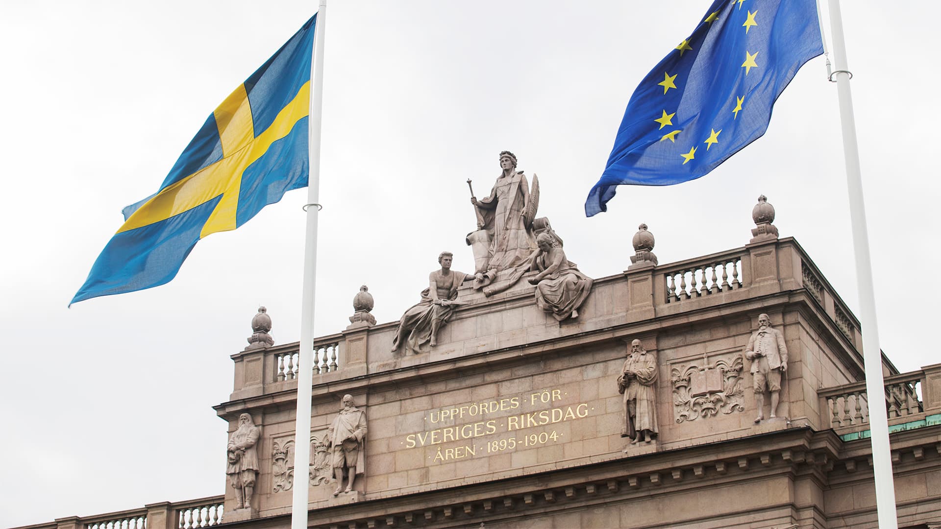 Svenska och europeiska flaggan framför riksdagshuset