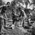 Fyra män vaskar grus i jakt på mineraler