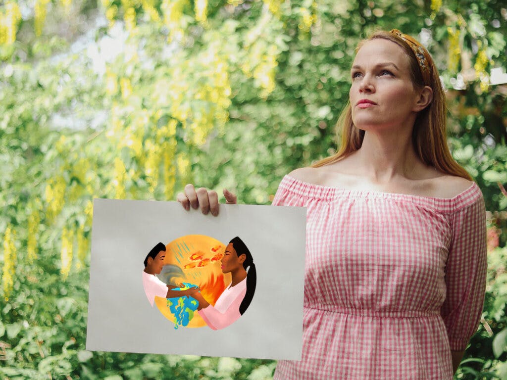 En kvinna håller en bild som visar människor vid naturkatastrof