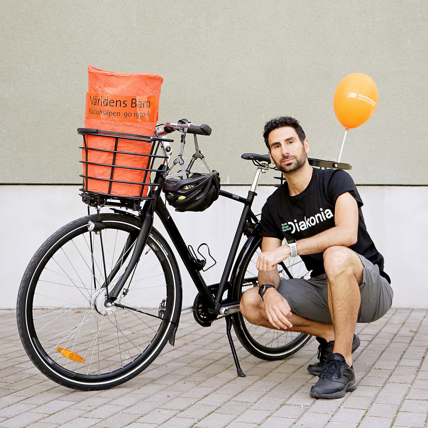Man sitter på huk vid cykel