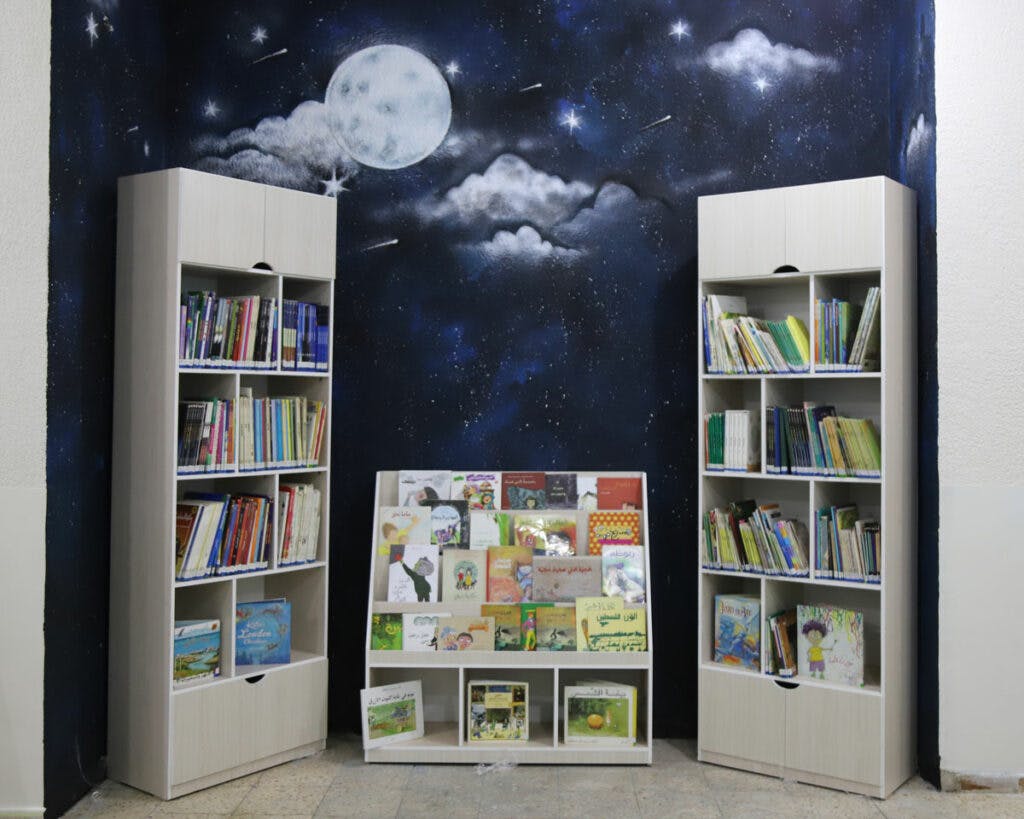 En vägg målad som en himmel och hyllor med barnböcker