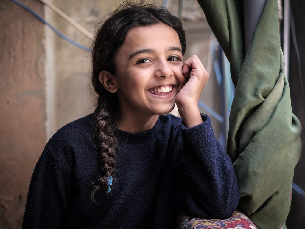 Foto på leende flicka i ett av Libanons flyktingläger