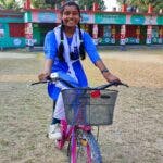 En flicka i skoluniform på cykel i Bangladesh