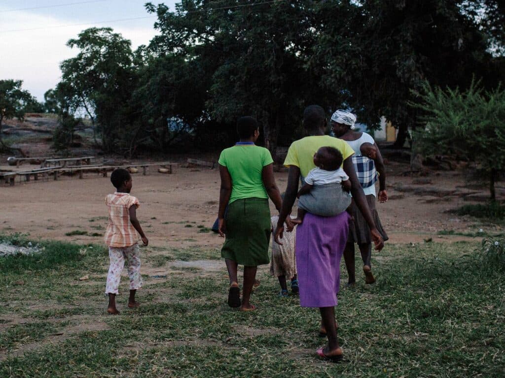 Grupp med kvinnor och barn går på gräsplan