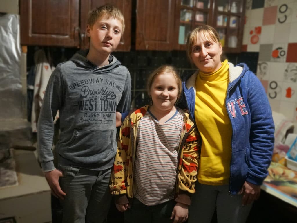 Foto: HIA/Act Alliance En kvinna och två barn tittar in i kameran.