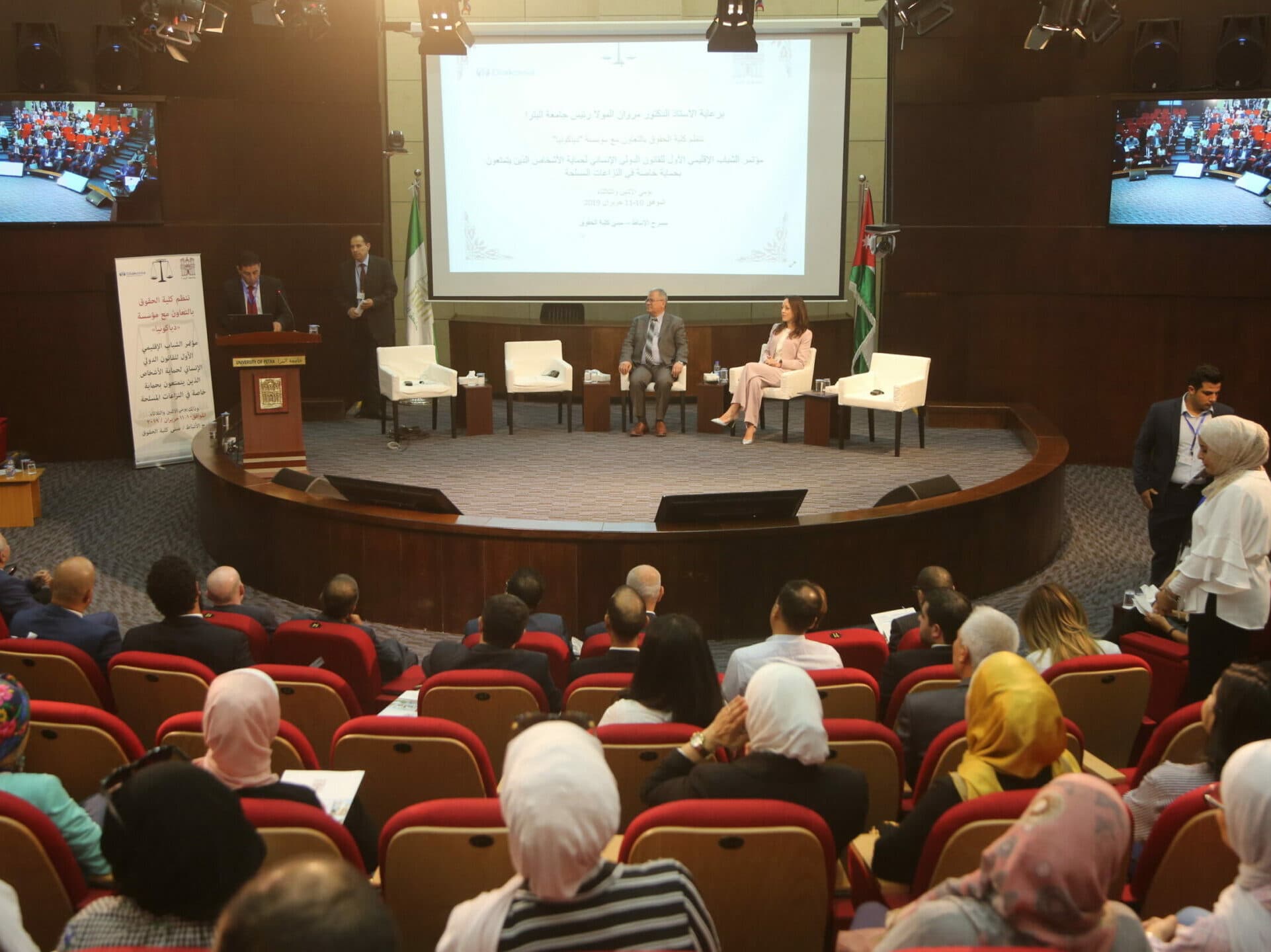 Persons watching a panel discussion.