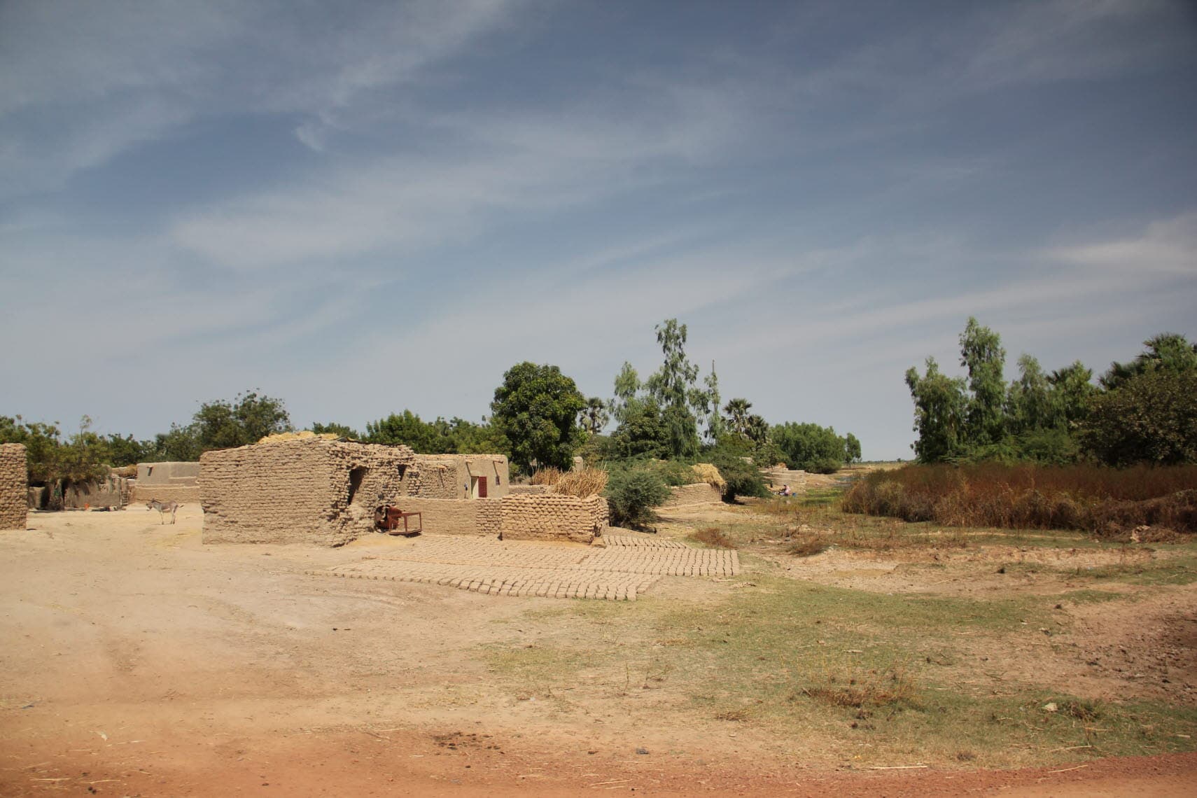 A hut of bricks and in the background trees.