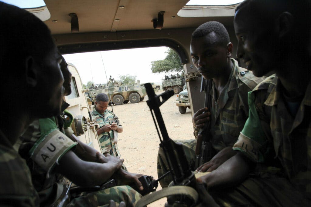 Soldiers sitting inside a military vehicle.