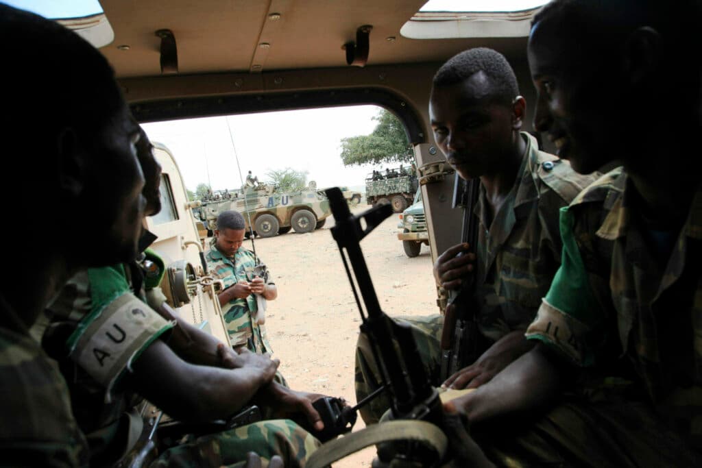 Soldiers sitting inside a military vehicle.