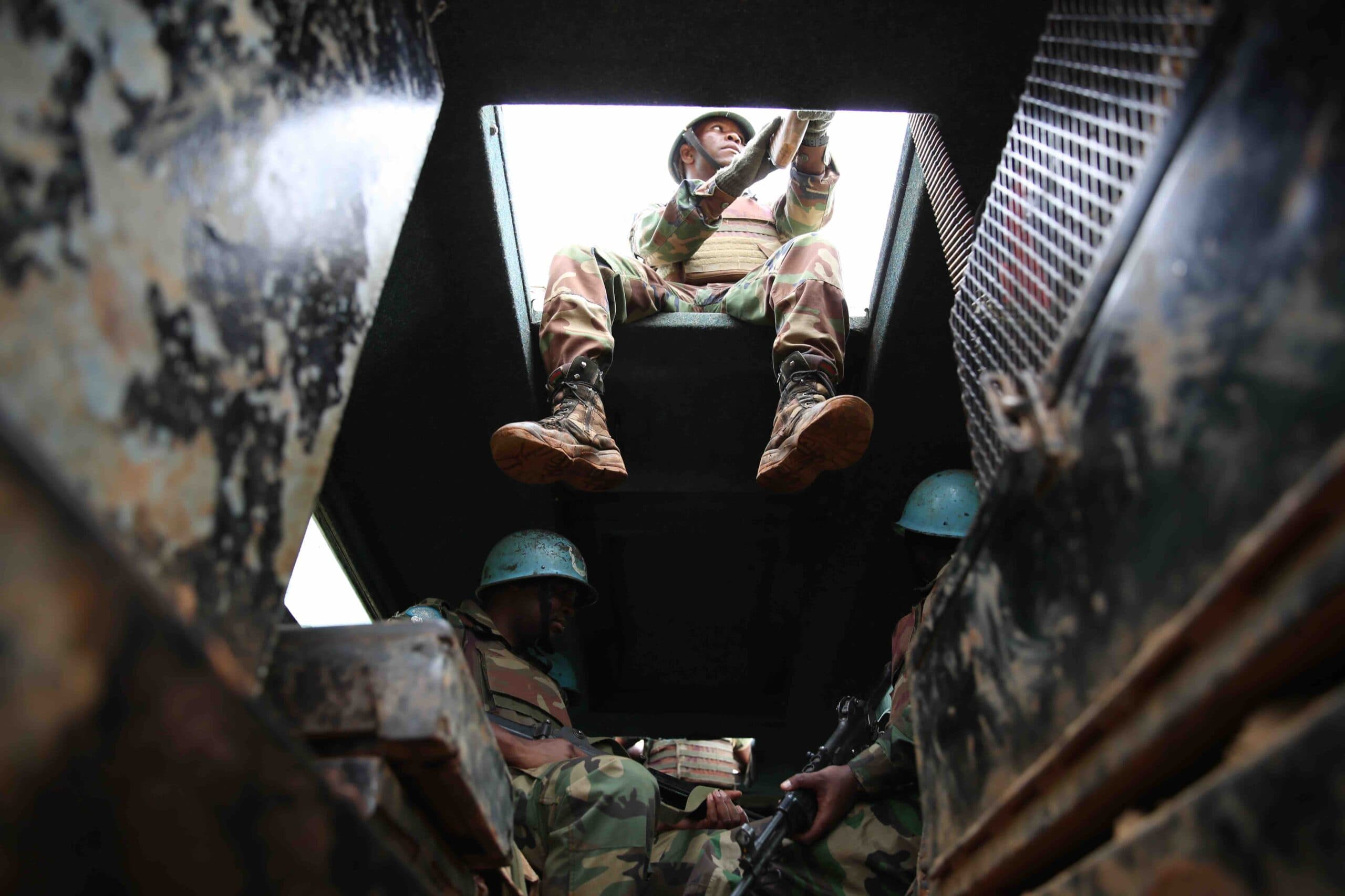 Soldiers with a blue helmet in a military vehicle.