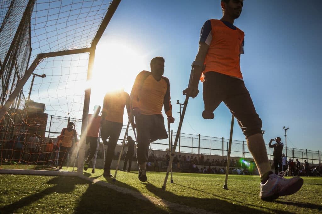 A group of football player with crutches on a field.