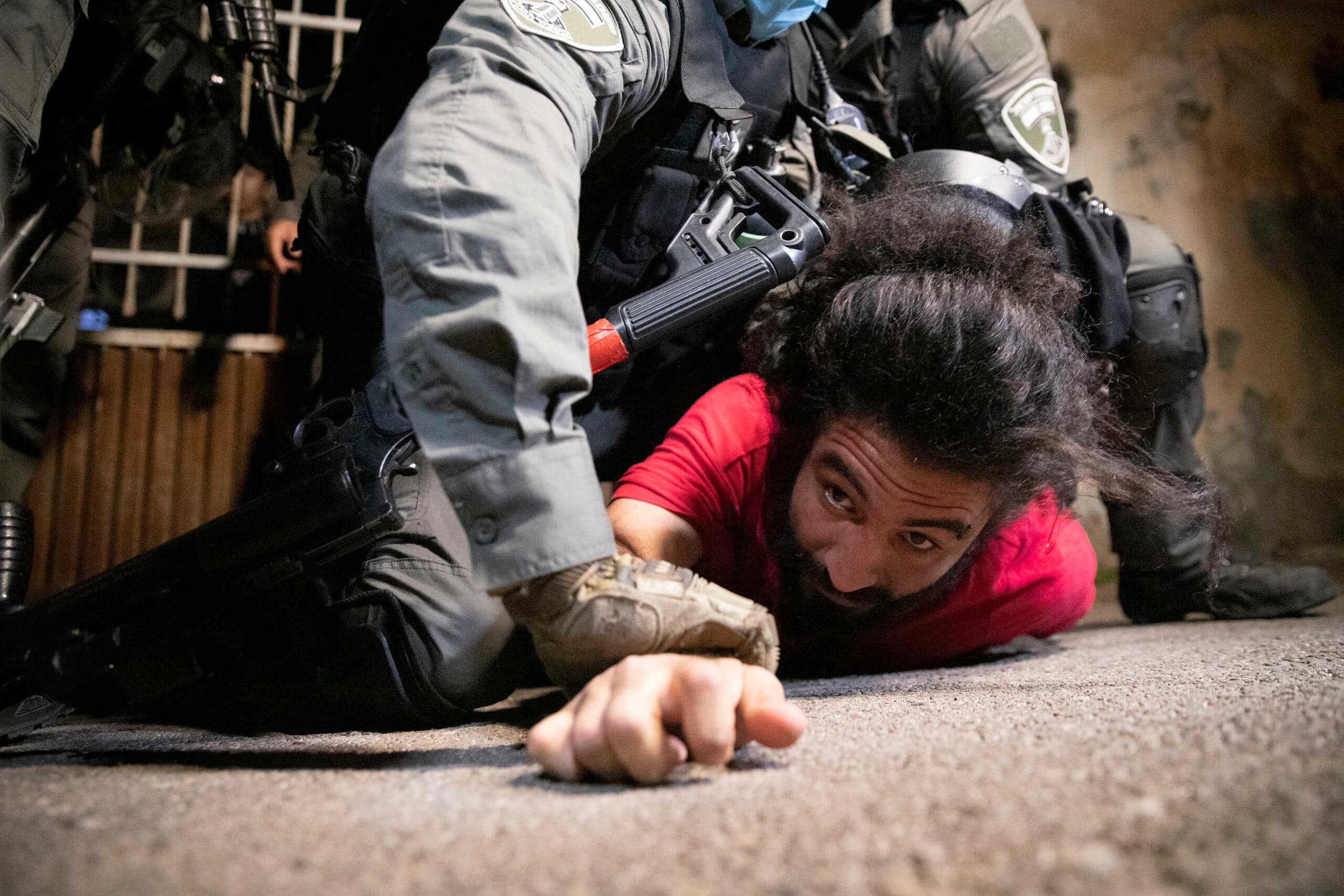 A person pressed down to the street by a security officer.