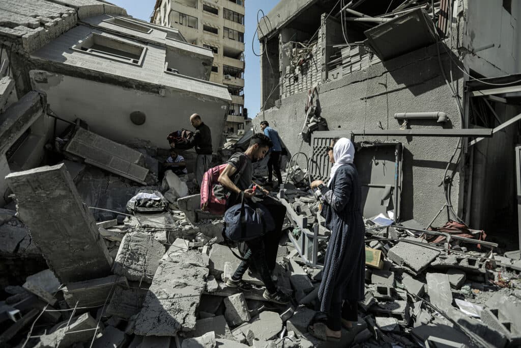 People climbing over the rubble of a destroyed building. People climbing over the rubble of a destroyed building.