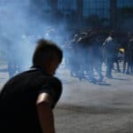 The silhouette of a group of demonstrators in the smoke.