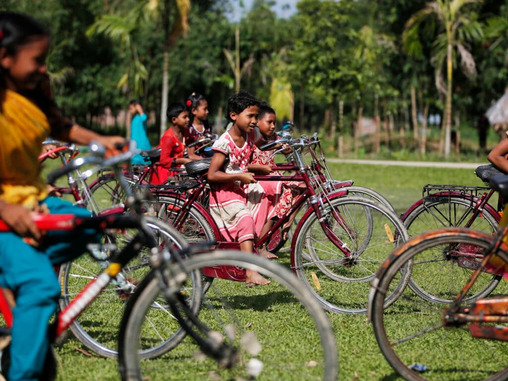 A little girl riding a big bicycle.