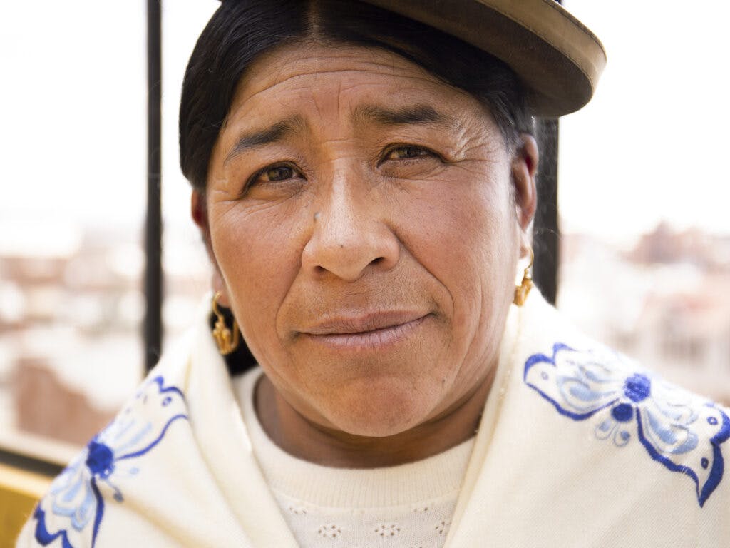 A closeup of a Bolivian woman wearing the traditional hat.