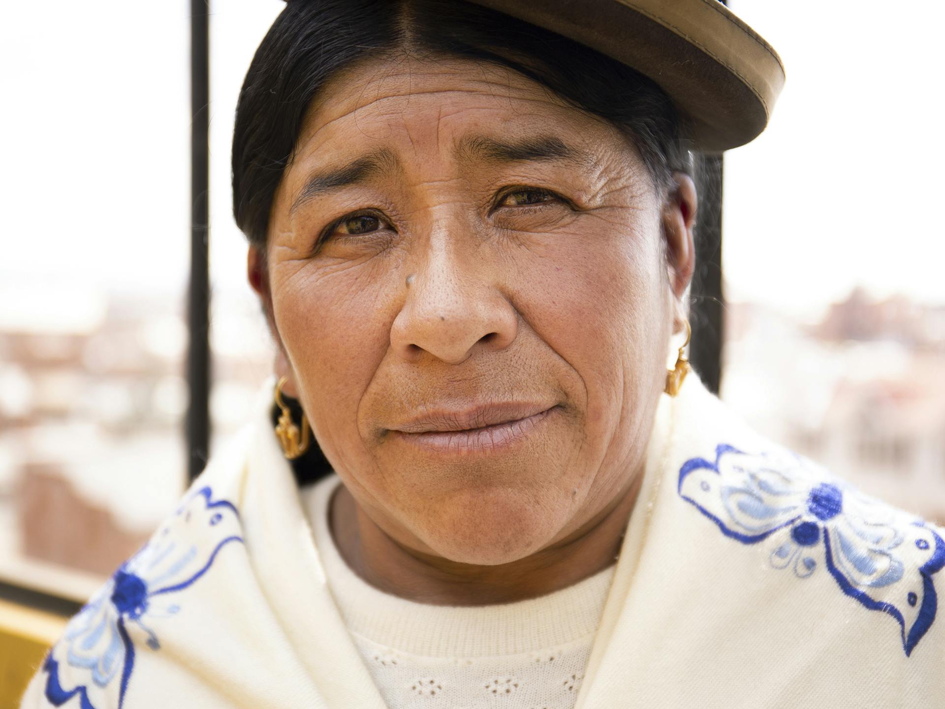 A closeup of a Bolivian woman wearing the traditional hat.