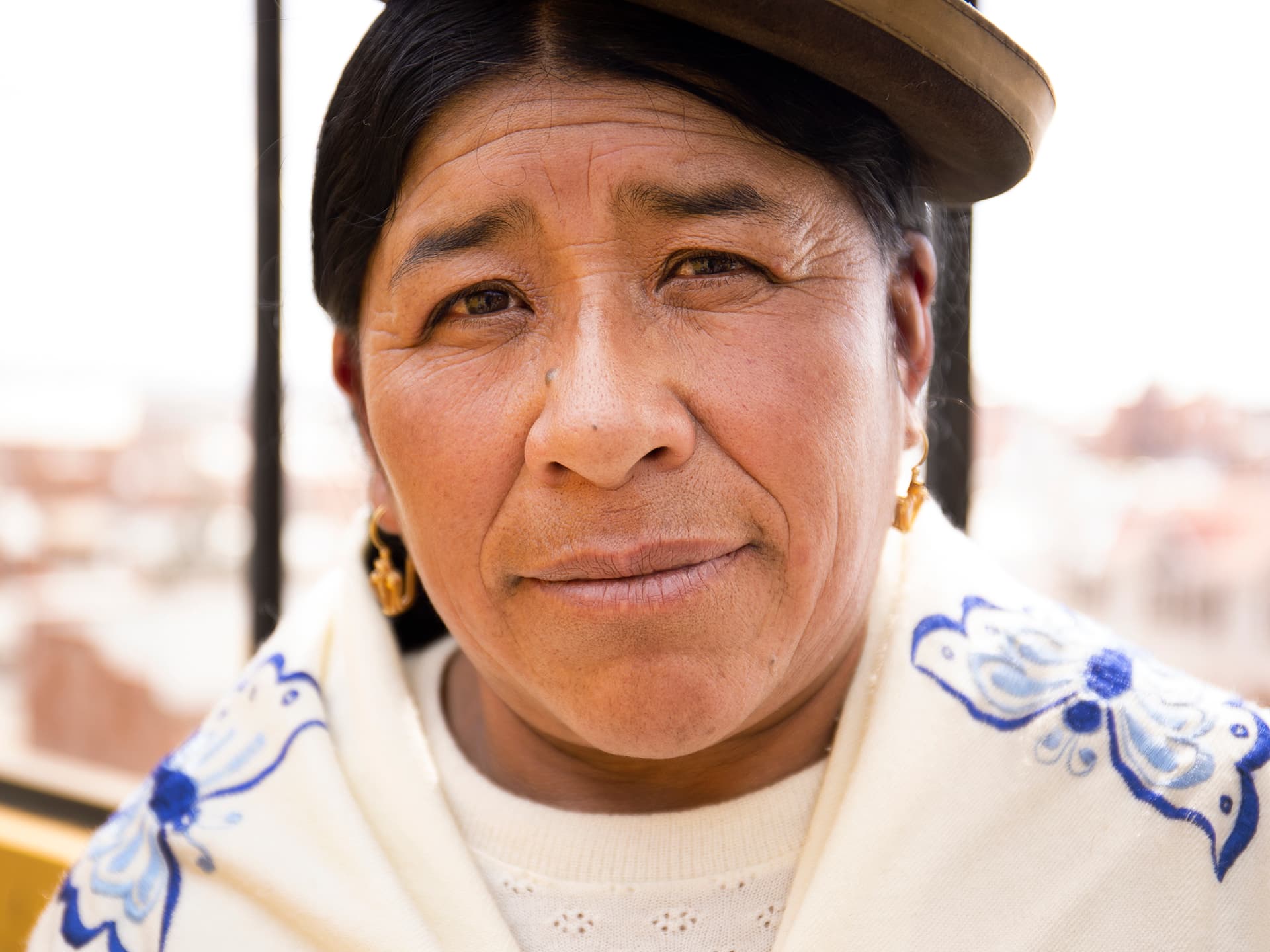 A closeup of a Bolivian woman wearing the traditional hat.